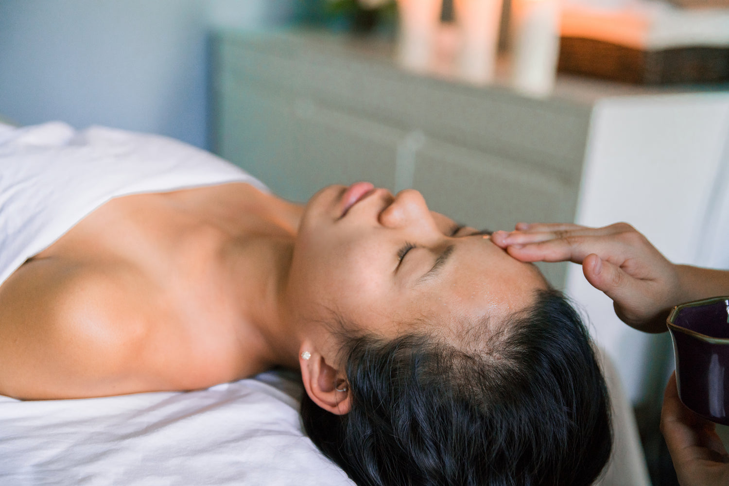A serene spa setting showcasing a woman receiving a luxury face lifting massage at Face by Greethel, focused on enhancing natural beauty with visible anti-aging effects.